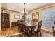 Formal dining room featuring hardwood floors, a modern chandelier, and large windows that flood the space with natural light at 7273 E Hinsdale Pl, Centennial, CO 80112