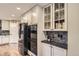 The kitchen features granite countertops, sleek stainless steel appliances, and ample storage space with white cabinets, and glass front uppers at 7273 E Hinsdale Pl, Centennial, CO 80112