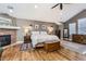A spacious main bedroom features hardwood floors, a brick fireplace, a ceiling fan, and plenty of natural light at 7273 E Hinsdale Pl, Centennial, CO 80112