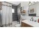 Modern bathroom featuring a shower and tub with dark gray tiled walls and a wooden vanity at 10810 W Alamo Pl, Littleton, CO 80127