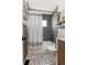 Stylish bathroom featuring patterned floors, dark gray tiled walls and a wooden vanity at 10810 W Alamo Pl, Littleton, CO 80127