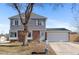 Charming two-story home with a brick and gray siding, a white garage door and a well-kept front lawn at 10810 W Alamo Pl, Littleton, CO 80127