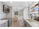 Modern kitchen features stainless steel appliances, grey cabinetry, quartz countertops, and decorative backsplash at 10810 W Alamo Pl, Littleton, CO 80127