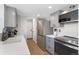 Well-lit kitchen features stainless steel appliances, quartz countertops, gray cabinets, and wood-look flooring at 10810 W Alamo Pl, Littleton, CO 80127