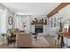 Cozy living room with a brick fireplace, light wood floors, and bright, natural light at 10810 W Alamo Pl, Littleton, CO 80127