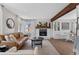 Cozy living room with a brick fireplace, light wood floors, and bright, natural light at 10810 W Alamo Pl, Littleton, CO 80127