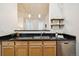 Kitchen featuring wood cabinets, black countertops, stainless steel appliances, with stainless steel dishwasher at 444 17Th St # 208, Denver, CO 80202