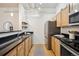 Kitchen features wood cabinets, black countertops, stainless steel appliances, and hardwood flooring at 444 17Th St # 208, Denver, CO 80202