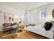 Living area with couch, coffee table, rug, art, bedroom area, and hardwood floors at 444 17Th St # 208, Denver, CO 80202
