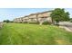 A well-maintained row of townhomes sits on a lush green lawn at 9770 Dahlia Ln, Thornton, CO 80229