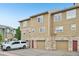 Townhome featuring a stone facade, garage, wood siding, and red front doors at 9770 Dahlia Ln, Thornton, CO 80229