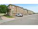 Townhome complex featuring a stone facade, garages, wood siding, and well manicured landscaping at 9770 Dahlia Ln, Thornton, CO 80229