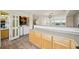 Open kitchen area featuring light wood cabinets, laminate flooring, and a laundry room at 9770 Dahlia Ln, Thornton, CO 80229