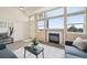 Sunlit living room with a cozy fireplace and view of the outdoors at 9770 Dahlia Ln, Thornton, CO 80229