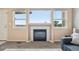 Living room featuring a charming fireplace and abundant natural light through large windows at 9770 Dahlia Ln, Thornton, CO 80229