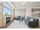 Bright living room featuring a fireplace, large windows with views, and modern grey sofas at 9770 Dahlia Ln, Thornton, CO 80229