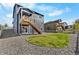 A view of the backyard with wood deck, rock landscape and modern two-story home at 4851 Cattle Cross Rd, Castle Rock, CO 80104