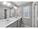 Bright bathroom with double vanity, large mirror, and a window for natural light at 4851 Cattle Cross Rd, Castle Rock, CO 80104