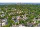 An aerial view showing the house and neighborhood nestled among mature trees, city view in background at 521 Harrison St, Denver, CO 80206