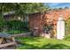 A lush green backyard featuring a brick wall, a brick waterfall feature and a picnic table at 521 Harrison St, Denver, CO 80206