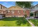 The backyard features a red brick exterior, lush green grass, a gazebo and mature landscaping at 521 Harrison St, Denver, CO 80206