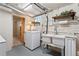 A functional laundry area featuring a double sink, washer, and storage space in the unfinished basement at 521 Harrison St, Denver, CO 80206