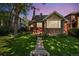 Charming brick home featuring a well-maintained front yard with mature tree and inviting walkway at 521 Harrison St, Denver, CO 80206