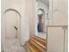 Hallway featuring unique archways, white walls, and a glimpse into the kitchen and a set of stairs at 521 Harrison St, Denver, CO 80206