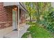 Side yard featuring a well-maintained lawn, brick siding, and mature trees providing ample shade at 521 Harrison St, Denver, CO 80206
