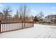 Wooden deck in snowy backyard with tree at 4072 S Kirk Way, Aurora, CO 80013