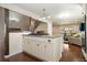 Open kitchen with white cabinets, island, stainless appliances, and view to the living room at 7069 Coors Ct, Arvada, CO 80004