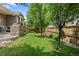 Backyard featuring a large lawn, mature trees, and a brick patio, ideal for outdoor enjoyment at 10182 Bristleridge St, Parker, CO 80134
