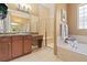 Well-lit bathroom with double sinks, separate shower, soaking tub, and granite countertop at 10182 Bristleridge St, Parker, CO 80134