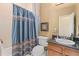 Traditional bathroom with shower curtain, dark granite countertop, and wood vanity at 10182 Bristleridge St, Parker, CO 80134