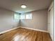 A bedroom boasts hardwood floors, fresh paint, and a corner window at 10025 W 8Th Ave, Lakewood, CO 80215