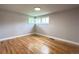 A bedroom boasts hardwood floors, fresh paint, and a corner window at 10025 W 8Th Ave, Lakewood, CO 80215