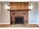 Close up of the brick fireplace with dark metal fire screen and wood detailing in the living room at 10025 W 8Th Ave, Lakewood, CO 80215
