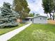 Charming single story home with manicured lawn and mature trees on a sunny day at 10025 W 8Th Ave, Lakewood, CO 80215