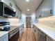 Kitchen featuring stainless steel appliances, plentiful counter space, and gray cabinets with black hardware at 10025 W 8Th Ave, Lakewood, CO 80215