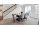 Elegant dining area with a modern table, comfortable chairs, and a staircase leading to the upper level at 7367 S Pennsylvania St, Littleton, CO 80122