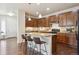 Modern kitchen with wooden cabinets, granite counters, stainless appliances, and an island with bar seating at 7367 S Pennsylvania St, Littleton, CO 80122
