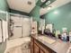 Bathroom featuring green walls, a shower with glass doors, and a wooden vanity with a dark countertop at 9150 Garrison St, Broomfield, CO 80021