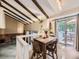 Bright dining area featuring vaulted ceilings with exposed wood beams and sliding glass doors to the outdoor patio at 9150 Garrison St, Broomfield, CO 80021