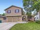 Two-story home with brick and stucco, featuring an arched brick entryway and a well-manicured lawn at 9150 Garrison St, Broomfield, CO 80021
