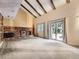 Spacious living room featuring brick fireplace, vaulted ceilings with wood beams, and sliding glass doors at 9150 Garrison St, Broomfield, CO 80021