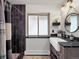 Bathroom featuring a sink with granite countertop, shower with dark tile and frosted glass window at 22155 Cook Ln, Morrison, CO 80465