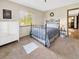 Bedroom featuring a black metal bedframe, a large window, a chest of drawers, and neutral carpeting at 22155 Cook Ln, Morrison, CO 80465