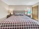 Bedroom with a plaid bedspread, two side tables, reading lamps, and a window with natural light at 22155 Cook Ln, Morrison, CO 80465