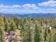 Expansive mountain view surrounded by lush green trees and valleys, offering a tranquil natural setting at 22155 Cook Ln, Morrison, CO 80465