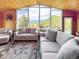 Comfortable living room with large windows offering scenic mountain views, complemented by cozy seating at 22155 Cook Ln, Morrison, CO 80465